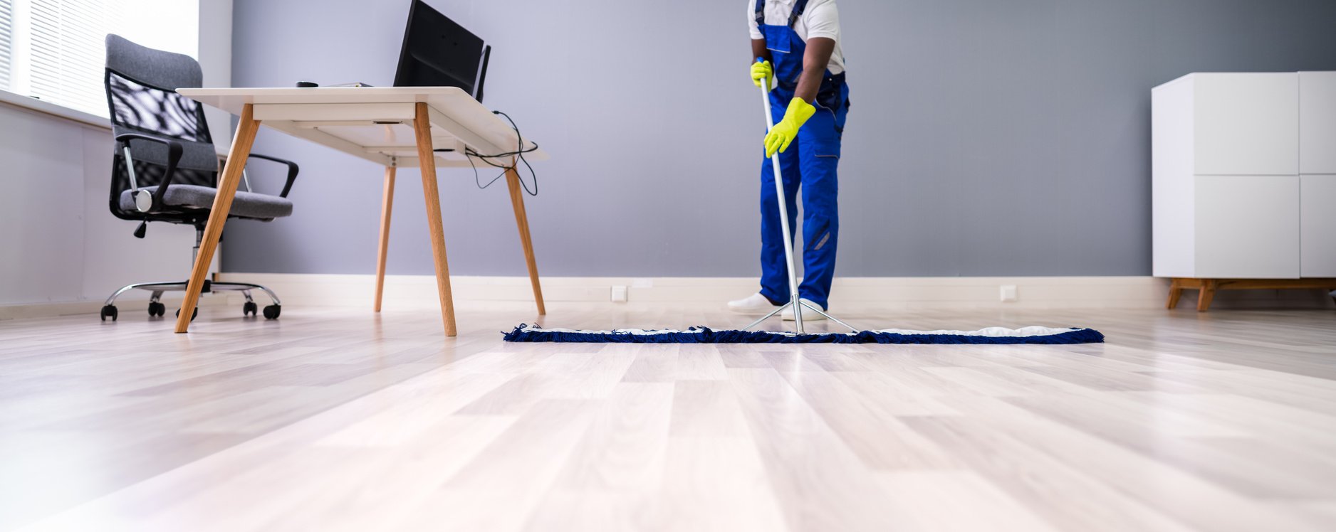 Male Janitor Cleaning Floor In Office