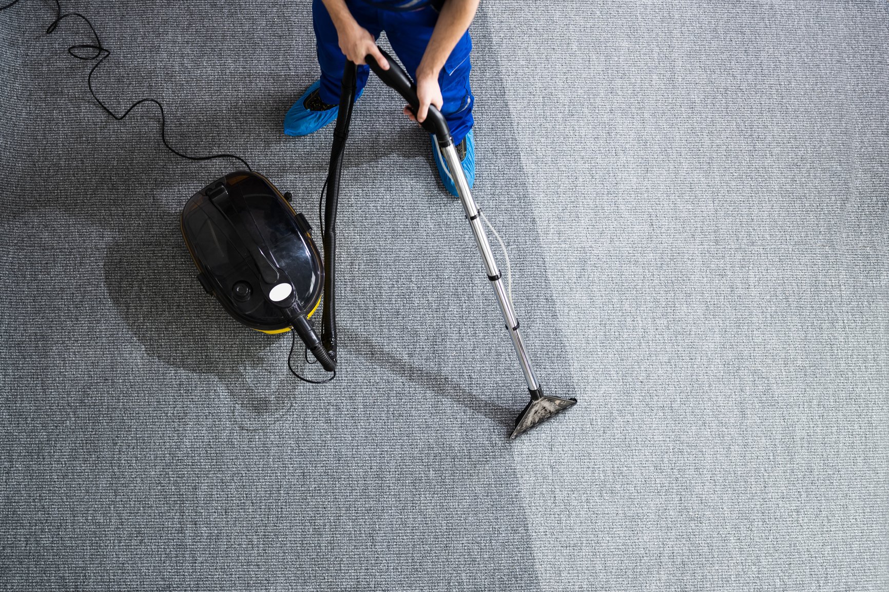 Janitor Cleaning Carpet With Vacuum Cleaner